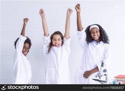 African black and caucasian students rising their hands after success on their project and graduate school. Education and Diversity Concept.