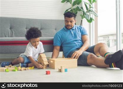 African black father is playing toys with his son in living room at home. Education and Family concept.