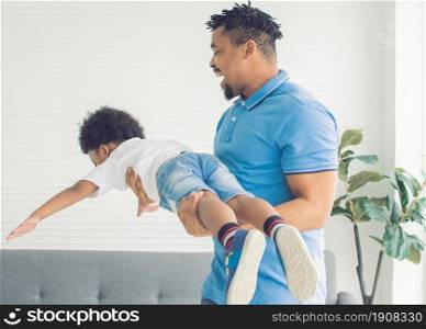 African black father is playing with his son in living room at home. Education and Family concept.