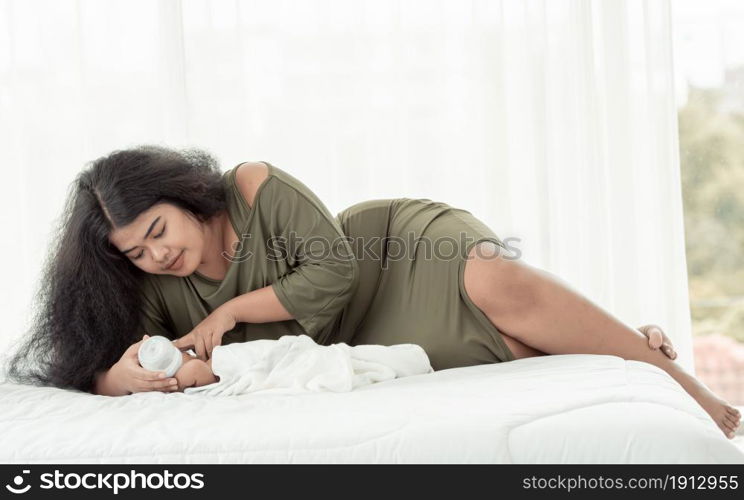 African black mother holding bottle of milk and feeding to her little baby with love and warmth. Family Concept.