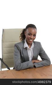 African business woman sitting at her desk and smiling isolated on white background