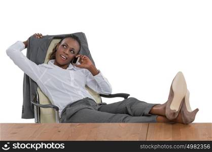 African business woman sitting at her desk and talking by phone isolated on white background