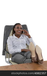 African business woman sitting at her desk and talking by phone isolated on white background