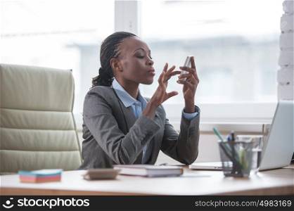 African Business woman texting with smartphone at office