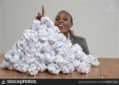African business woman with crumpled pile of papers at workplace at office