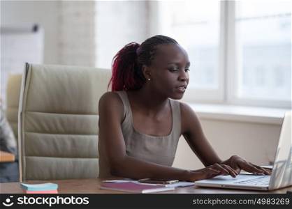 African business woman working in office environment using laptop