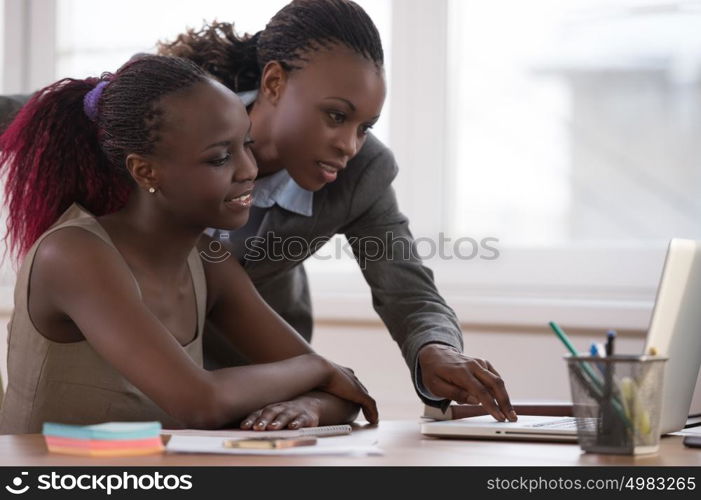 African business woman working with laptop and her colleague