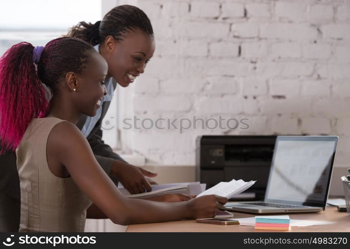 African business woman working with laptop and her colleague