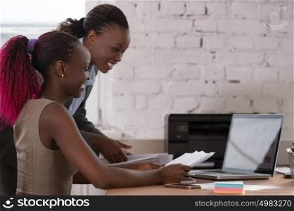 African business woman working with laptop and her colleague