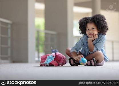 African children curly hair sitting under building with globe on hand .Concept for research global warming,climate change, global network,SEO search engine and Kid Education.