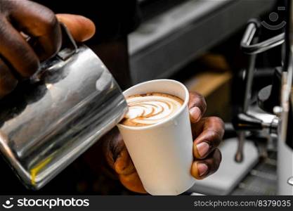 African Coffee Barista pouring a heart shape design with milk foam 