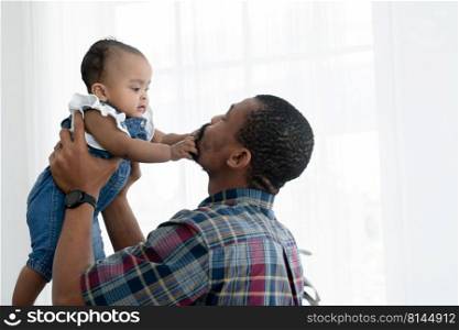 African father with beard playing and carrying his newborn baby girl up in the air and little cute kid have fun to pull dad"s beard at home. Relationship of dad and small daughter. White background
