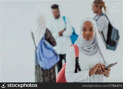 African female student with a group of friends in the background wearing traditional Islamic hijab clothes. Selective focus. High-quality photo. African female student with group of friends in background wearing traditional Islamic hijab clothes. Selectve focus 