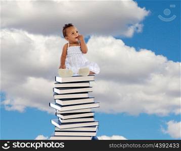 African girl sitting on a high stack of books with blue sky of background&#xA;