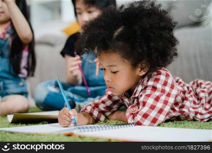 African kids drawing and do homework in classroom, young girl happy funny study and play painting on paper at elementary school. Kid drawing and painting at school concept.