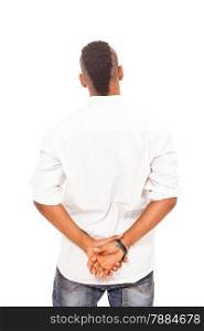 African man looking at the white wall with crossed hands behind his back over white isolated background