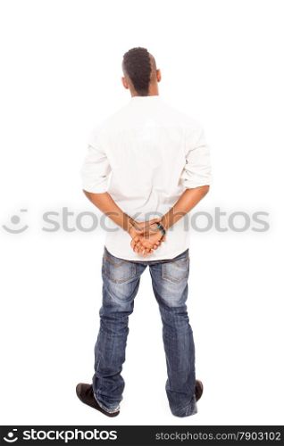 African man looking at the white wall with crossed hands behind his back over white isolated background