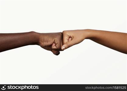 African man touching knuckles with dark-skinned woman as sign of agreement, partnership and cooperation. Two people holding hands in fist bump while greeting each other in informal modern handshake