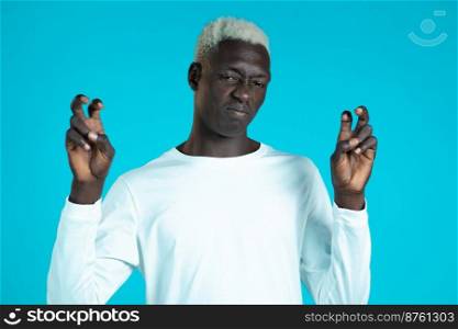 African man with white hairdo showing with hands and two fingers like"es gesture, bend fingers isolated over blue background. Very funny, irony and sarcasm concept. African man with white hairdo showing with hands and two fingers like"es gesture, bend fingers isolated over blue background. Very funny, irony and sarcasm concept.
