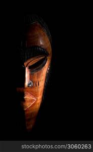 African mask. Travel souvenirs isolated on black background.