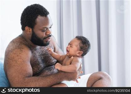 African middle aged bearded father is soothing newborn baby crying in his arms in bedroom at home. Single dad try to pacify cute infant alone. Family bonding concept