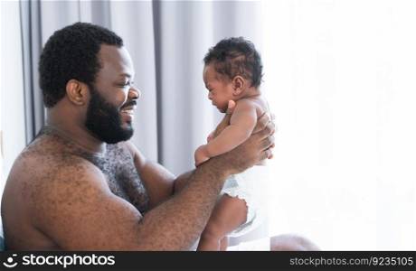 African middle aged bearded father smiling, carrying and soothing newborn baby crying in his arms and hands in bedroom at home. Single dad try to pacify cute infant alone. Family bonding concept