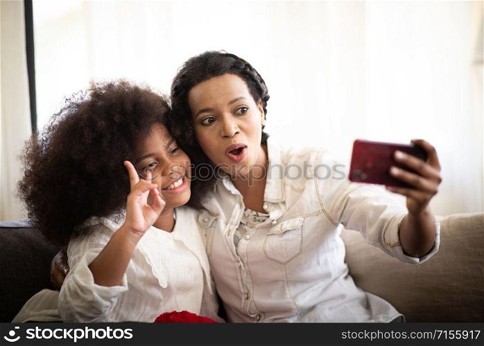 African mother and child Taking a photo with a smartphone.