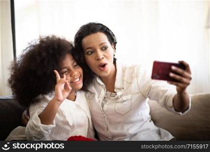 African mother and child Taking a photo with a smartphone.