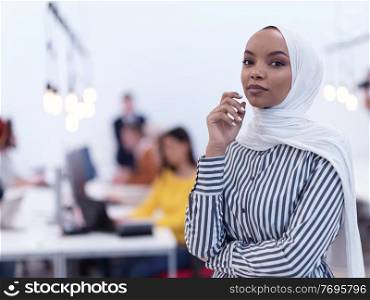 african muslim businesswoman portrait  wearing hijab at creative modern startup coworking open space office