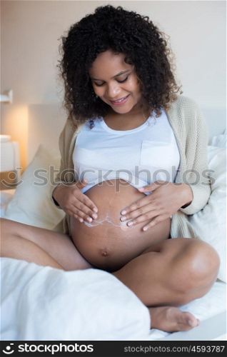 African Pregnant woman moisturizing her belly