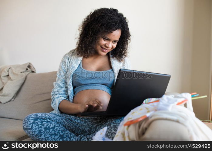 African pregnant woman shopping online for her baby