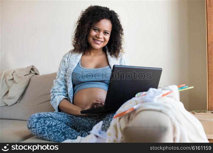 African pregnant woman shopping online for her baby