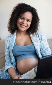 African pregnant woman shopping online for her baby