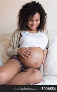 African Pregnant woman touching her 39 weeks belly