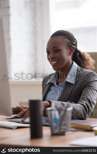 African pretty business woman working at pc in office
