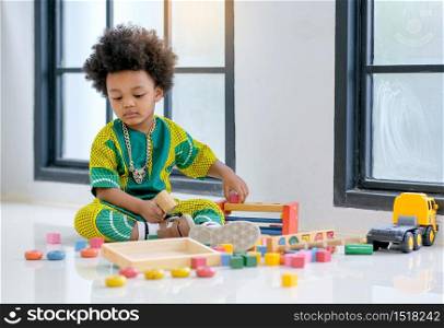 African young boy has fun with playing various type of toys.