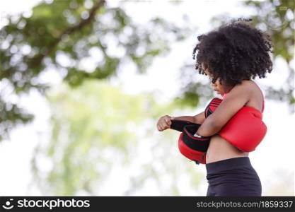 Afro American children wearing boxing gloves under the tree