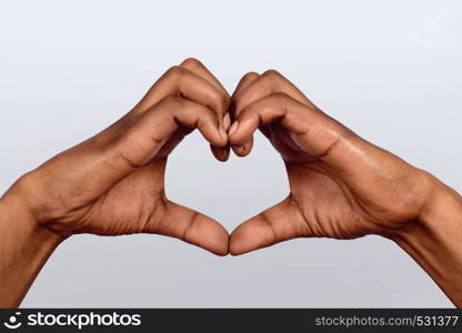 Afro American hand make heart shape on studio.