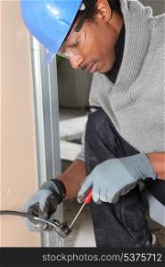 Afro-American laborer installing wiring