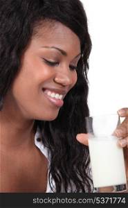 Afro-American woman smiling with glass of milk