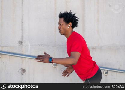 Afro athletic man doing exercise and running up stairs outdoors. Sport and healthy lifestyle concept.