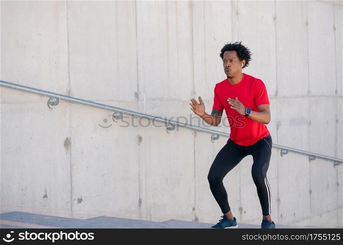Afro athletic man doing exercise outdoors at stairs. Sport and healthy lifestyle.