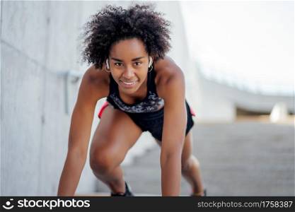 Afro athletic woman ready to run outdoors. Sport and healthy lifestyle.