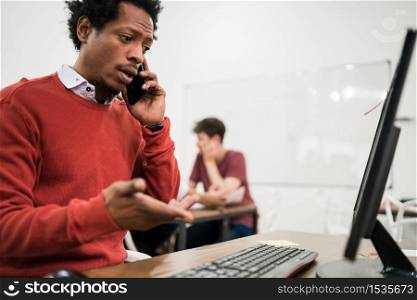 Afro businessman talking on the phone and working at his workplace. Business concept.