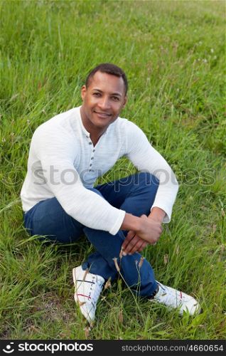 Afroamerican guy on a park sitting on the grass