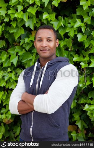 Afroamerican guy on a park with a plants of background