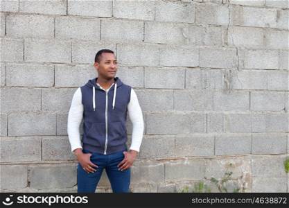 Afroamerican guy on the street with a wall background