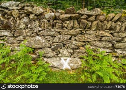 After a powder oil explosion 1869 wheel and harness found by this wall, X marks this Cwm y Glo, Llanberis, Wales, United Kingdom.