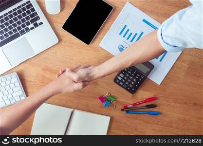 After agreeing to a contract, the businessman shakes hands and finishes the meeting in the daytime.