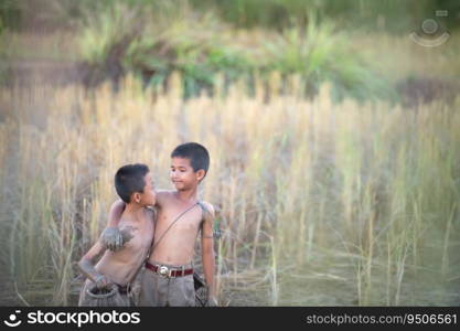 After class, little boys in rural Thailand like catching fish in the wetlands surrounding the rice fields to bring home to cook.